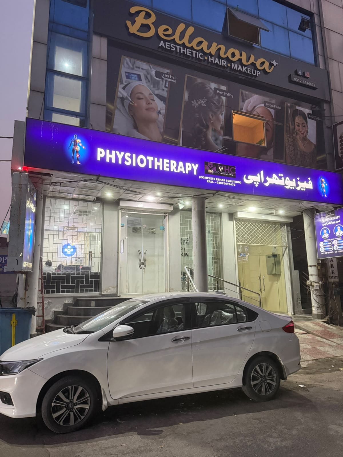 Physiodoctor physiotherapy clinic at night with illuminated purple signage